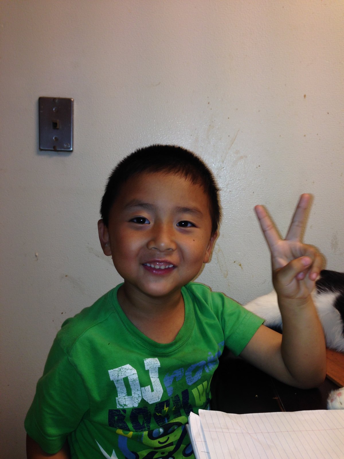 Francis Ruan as a young boy, grinning, holding up a peace sign
