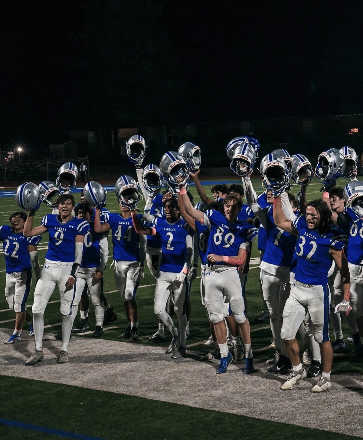 Los Altos football team with helmets raised