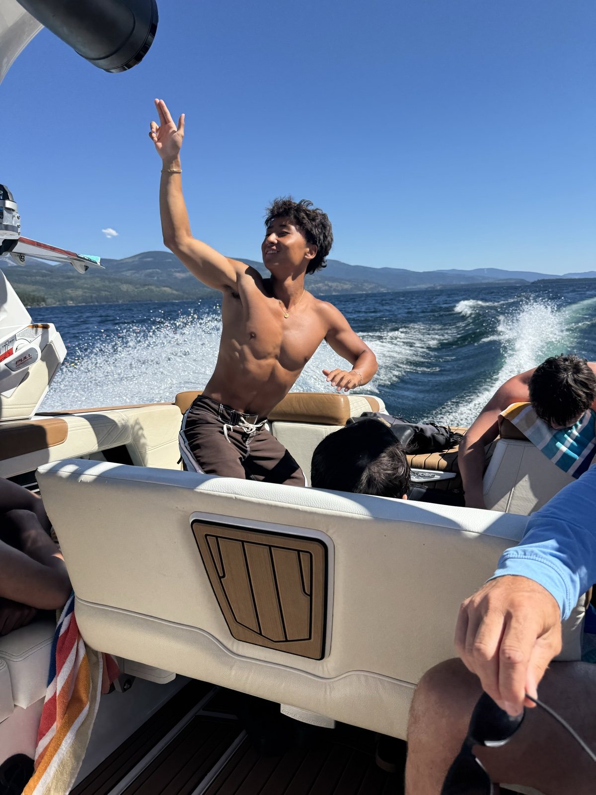 Francis Ruan on a boat with an arm raised