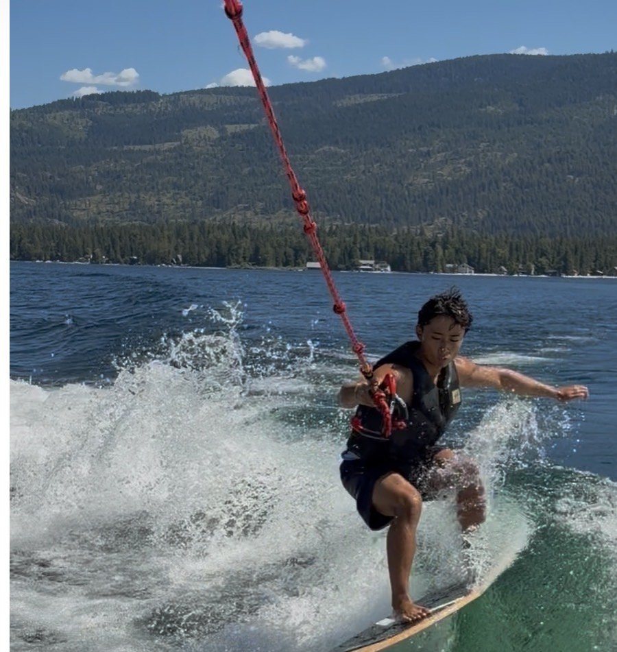 Francis Ruan riding a board behind a boat